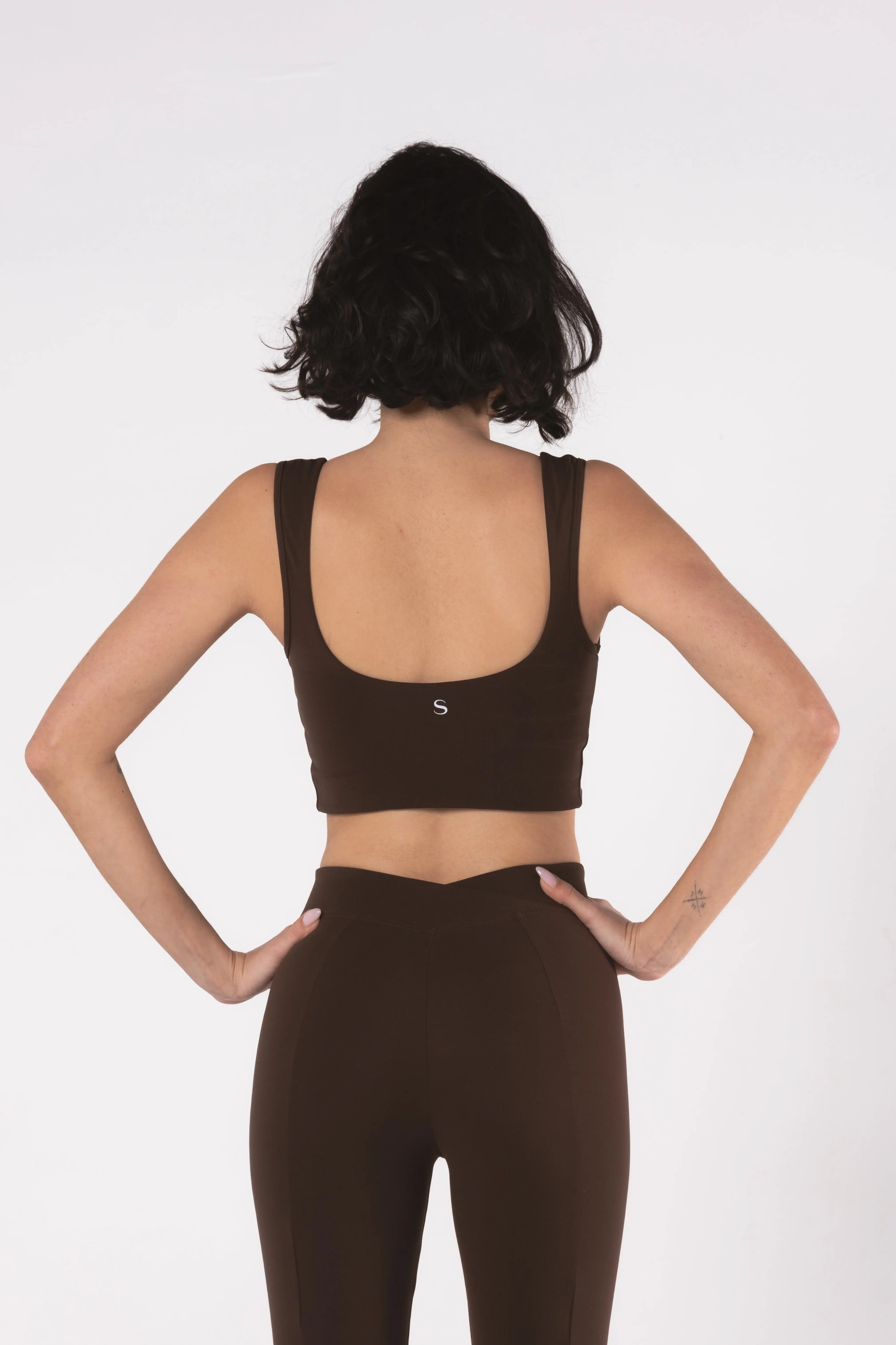 Woman wearing LESS Activewear Flow Sports Bra, designed for fuller busts
