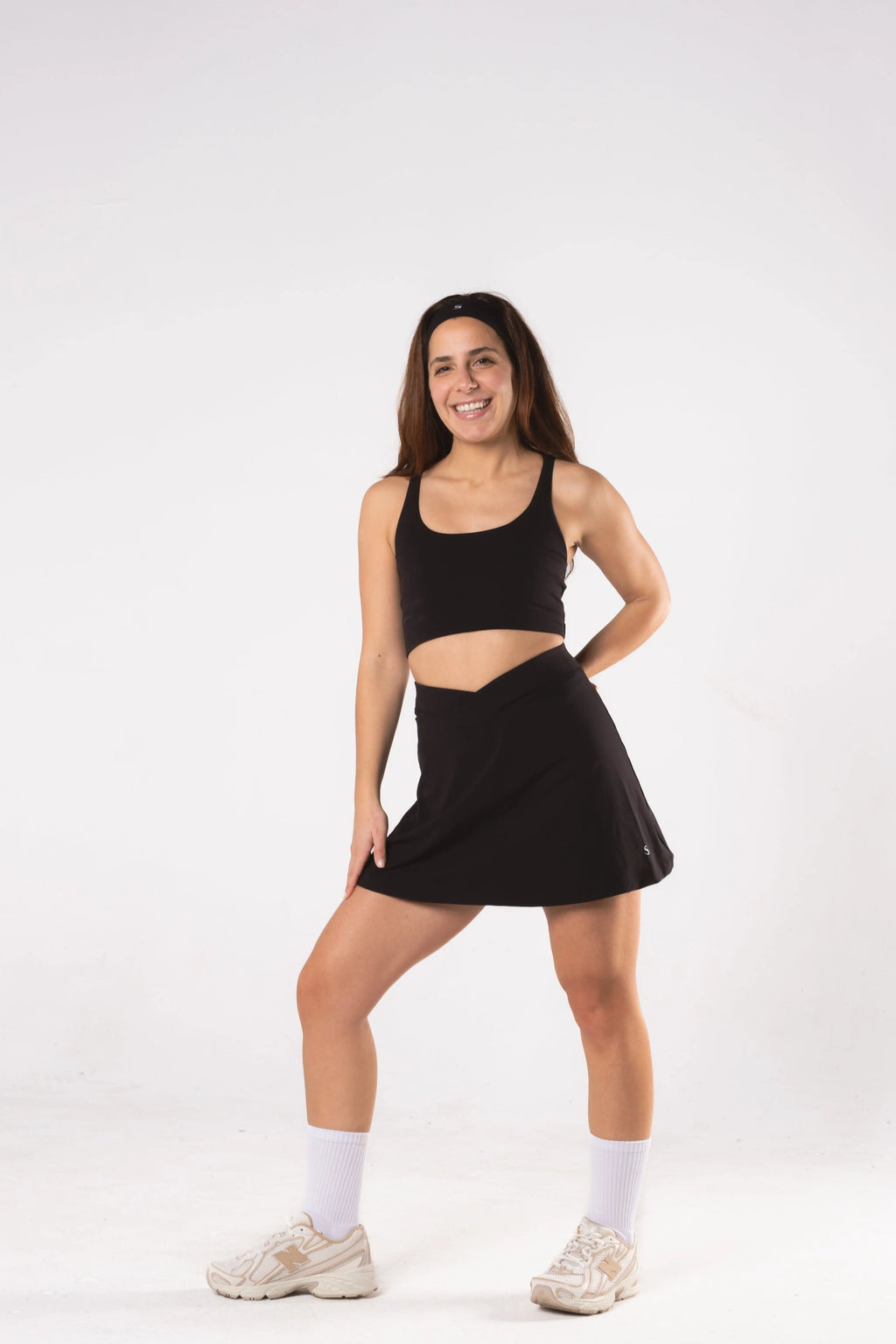 Woman wearing LESS Activewear Cross Sports Bra, recommended for fuller busts