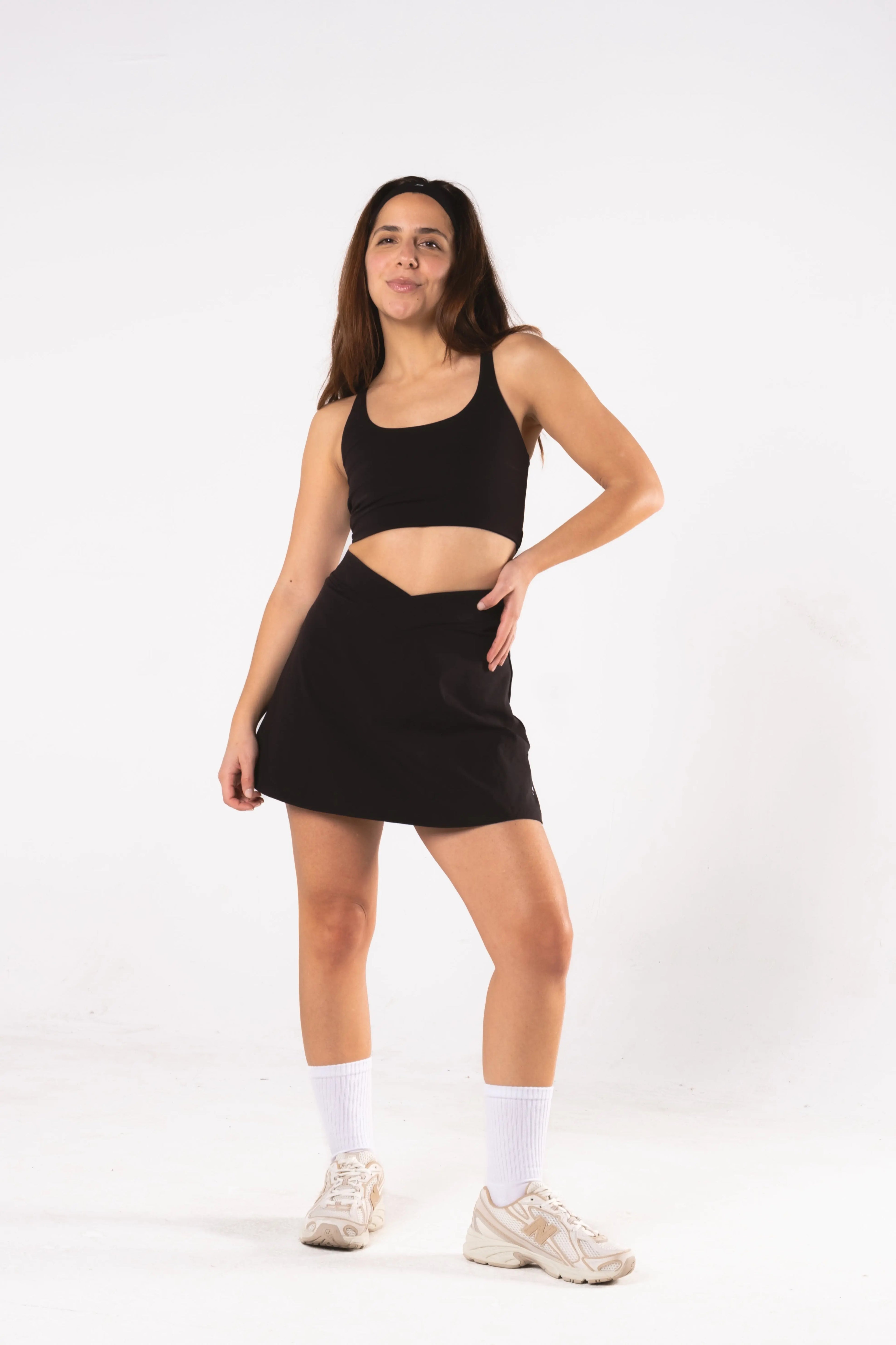 Woman wearing LESS Activewear Cross Sports Bra, recommended for fuller busts