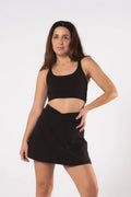 Woman wearing LESS Activewear Cross Sports Bra, recommended for fuller busts