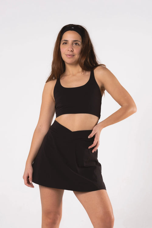 Woman wearing LESS Activewear Cross Sports Bra, recommended for fuller busts
