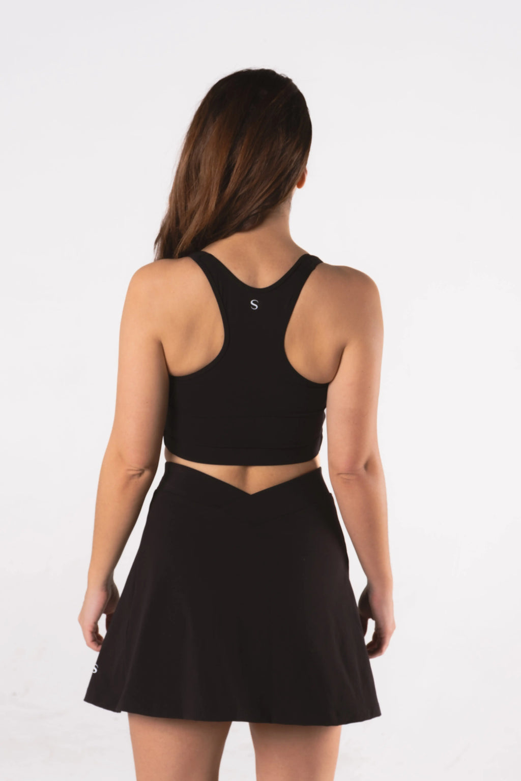 Woman wearing LESS Activewear Cross Sports Bra, recommended for fuller busts