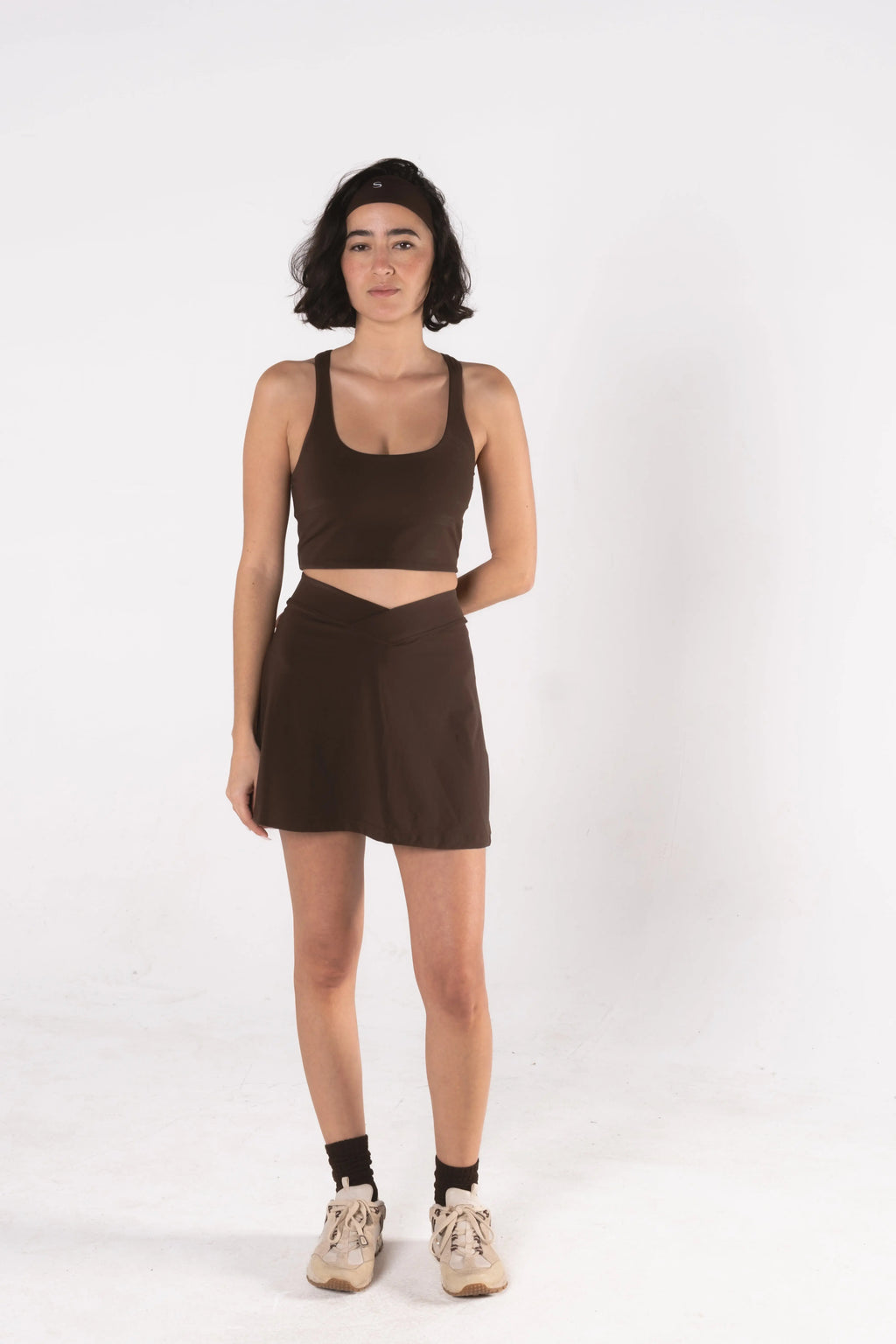 Woman wearing LESS Activewear Cross Sports Bra, recommended for fuller busts