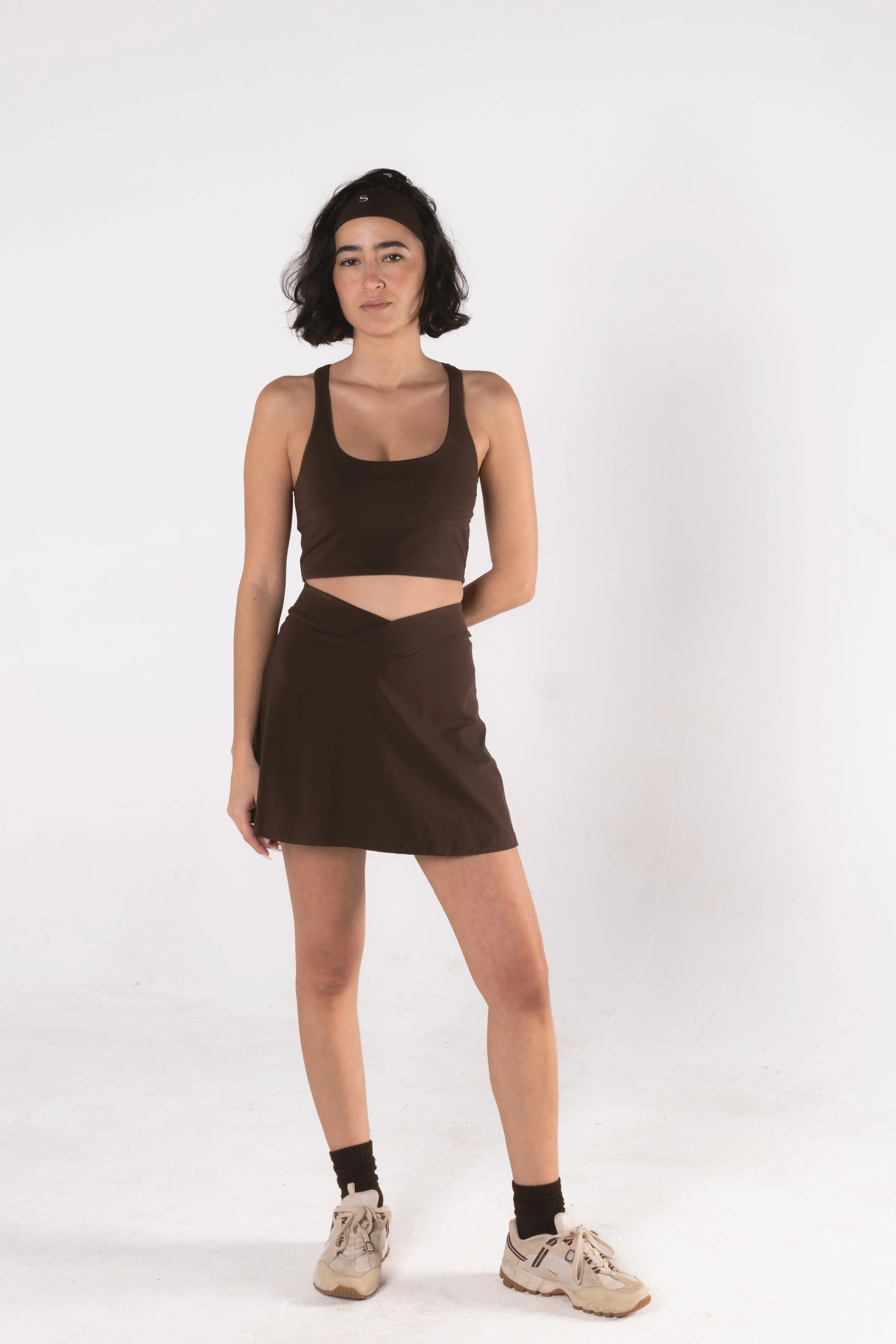 Woman wearing LESS Activewear Cross Sports Bra, recommended for fuller busts