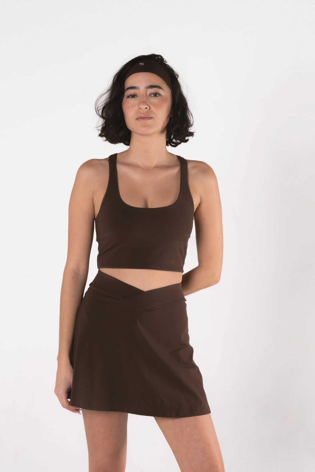Woman wearing LESS Activewear Cross Sports Bra, recommended for fuller busts
