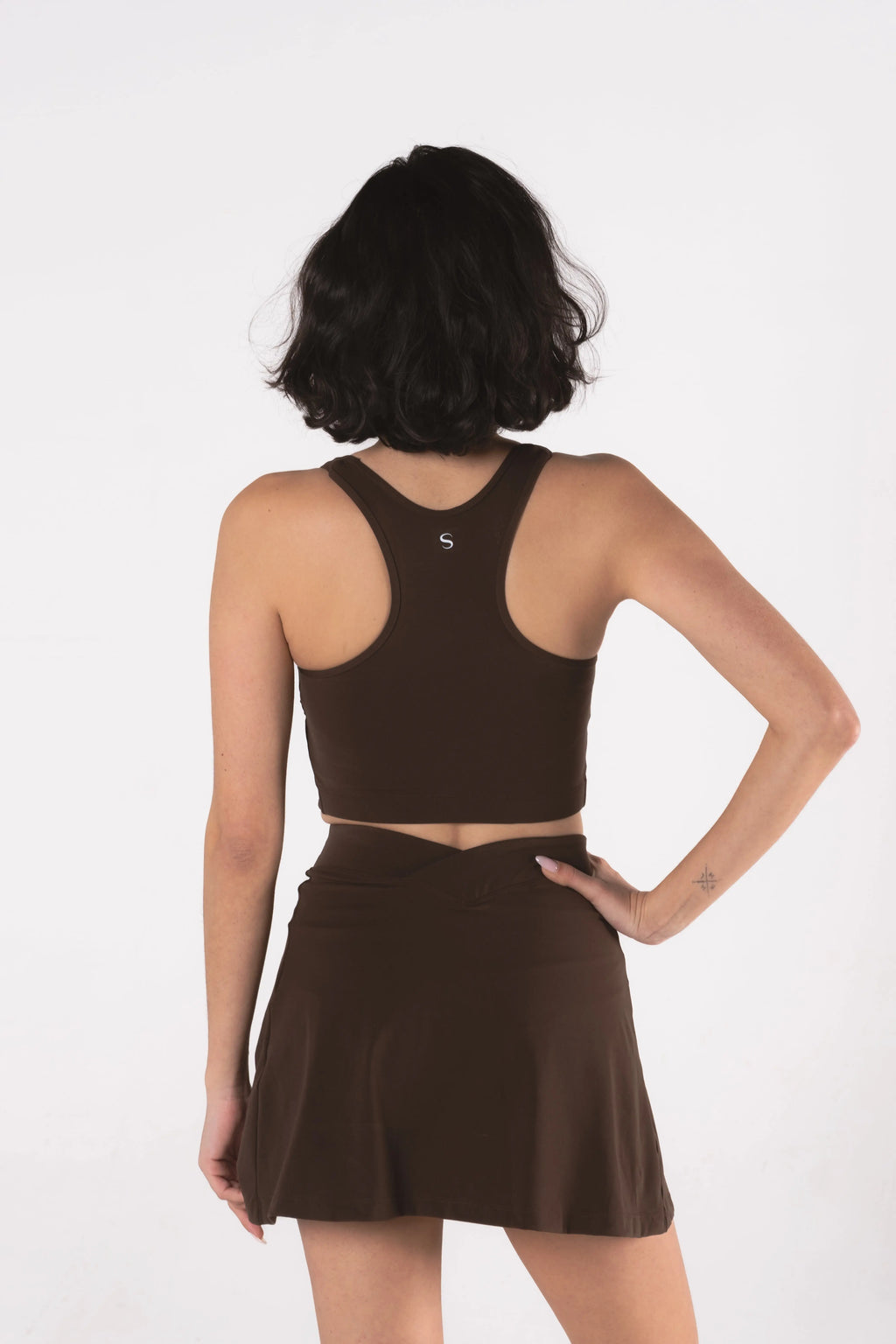 Woman wearing LESS Activewear Cross Sports Bra, recommended for fuller busts