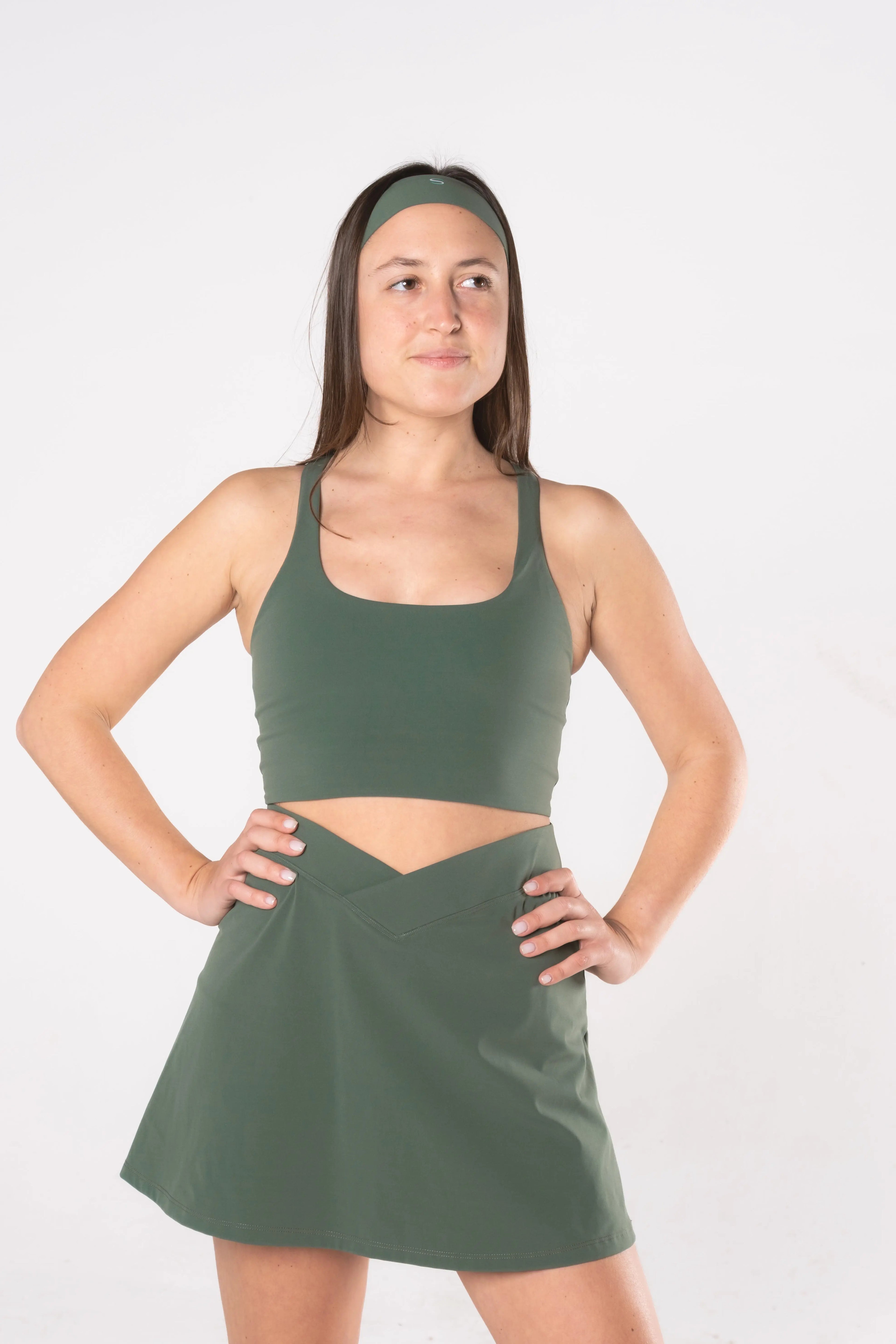 Woman wearing LESS Activewear Cross Sports Bra, recommended for fuller busts