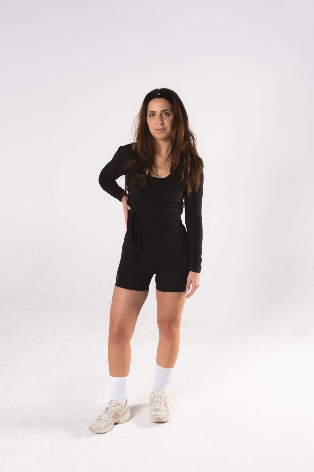 Woman wearing LESS Activewear Wrap Top, feminine coverage top for pilates