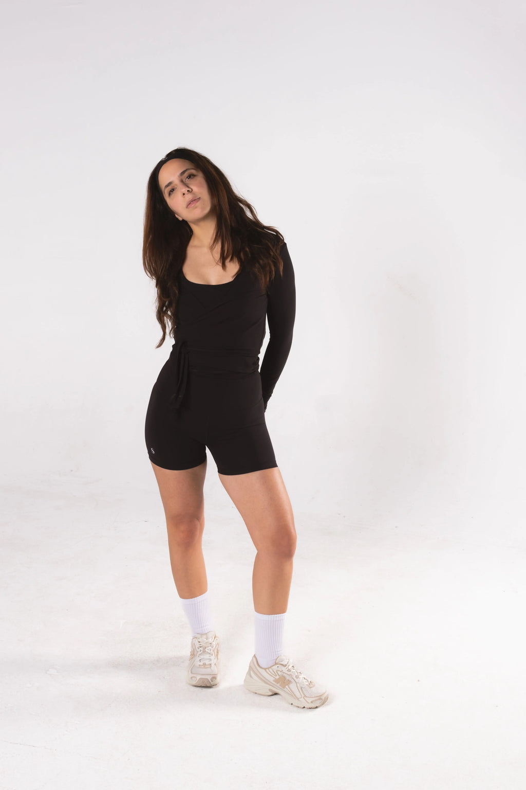Woman wearing LESS Activewear Wrap Top, feminine coverage top for pilates