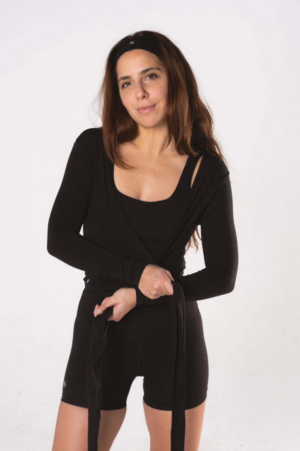 Woman wearing LESS Activewear Wrap Top, feminine coverage top for pilates