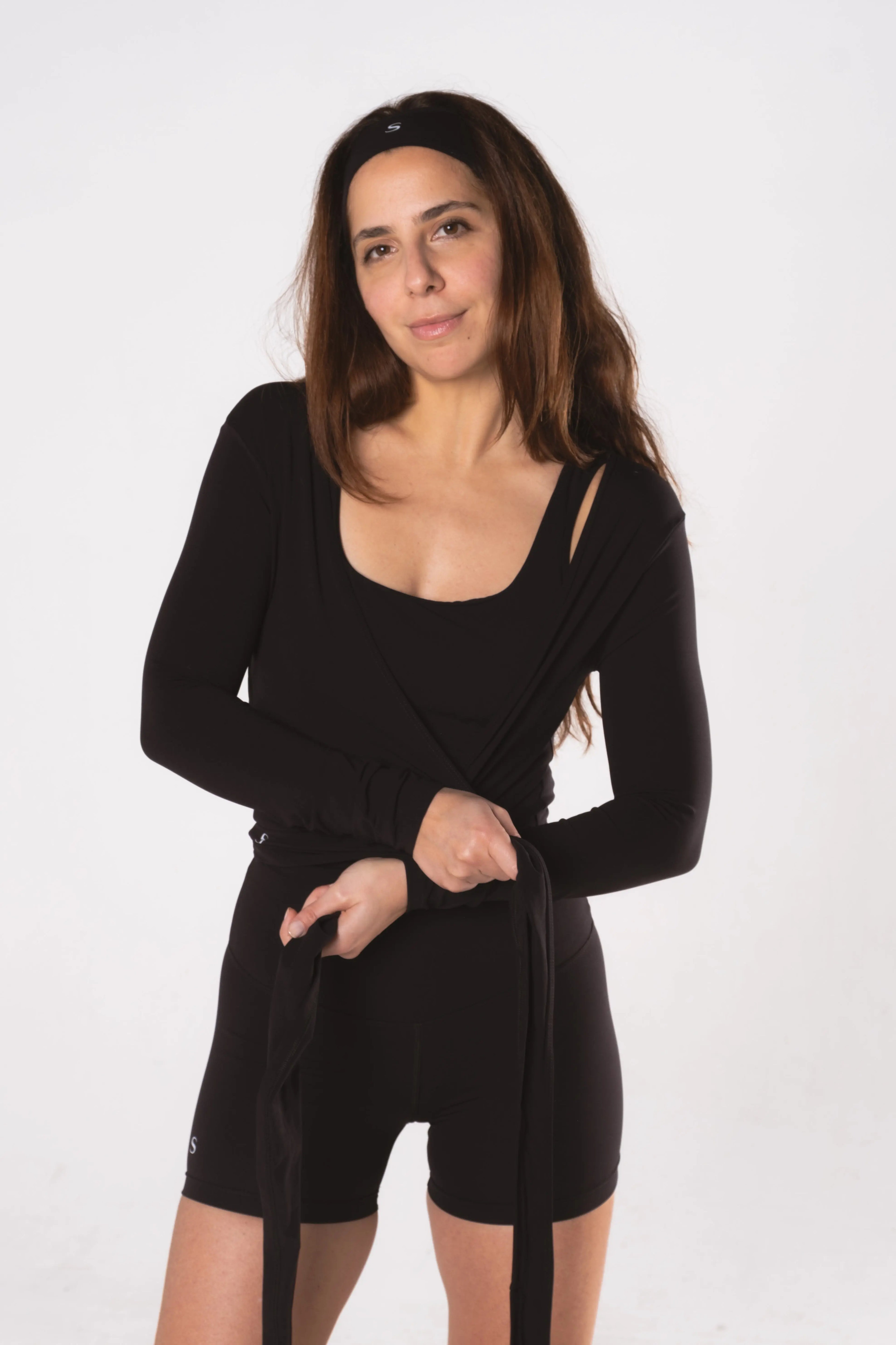 Woman wearing LESS Activewear Wrap Top, feminine coverage top for pilates
