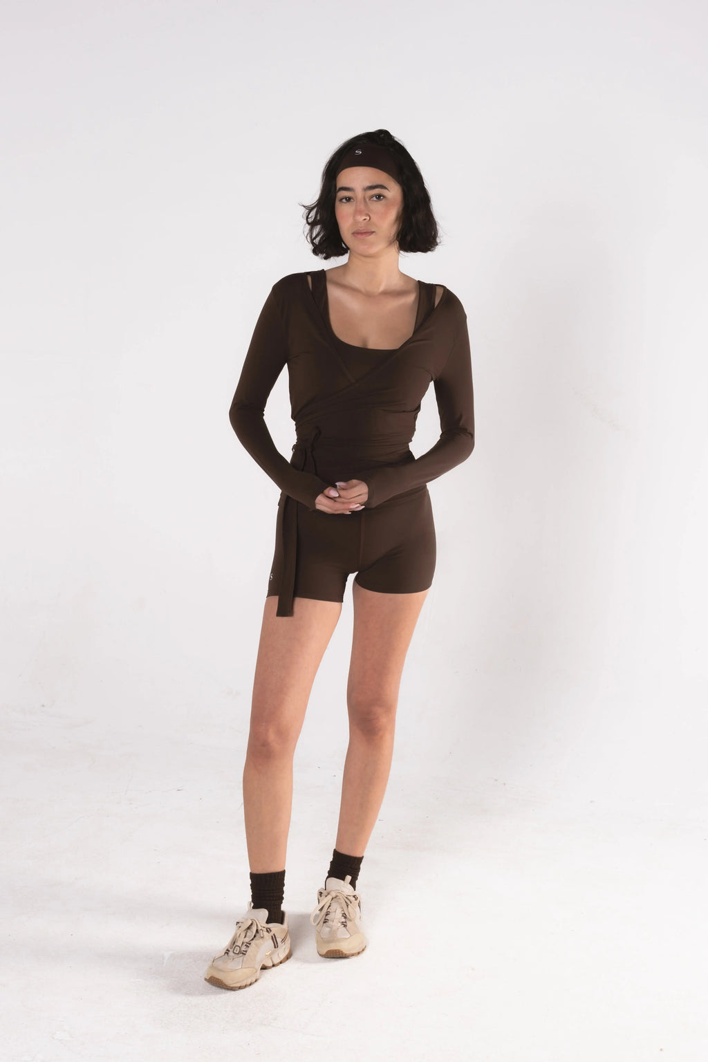 Woman wearing LESS Activewear Wrap Top, feminine coverage top for pilates
