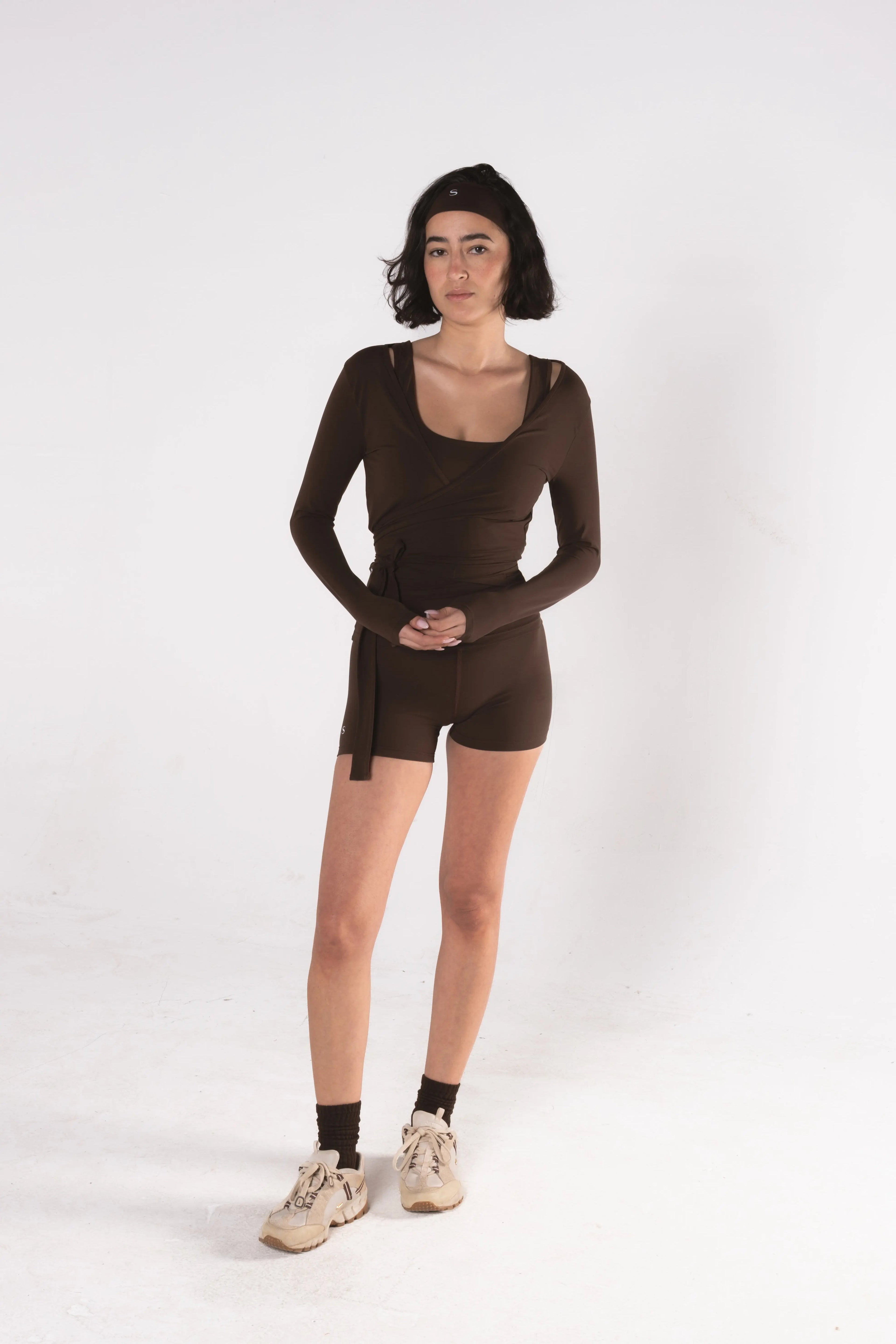 Woman wearing LESS Activewear Wrap Top, feminine coverage top for pilates