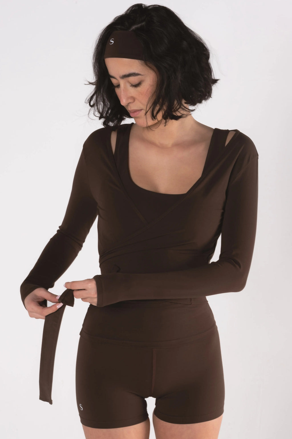 Woman wearing LESS Activewear Wrap Top, feminine coverage top for pilates