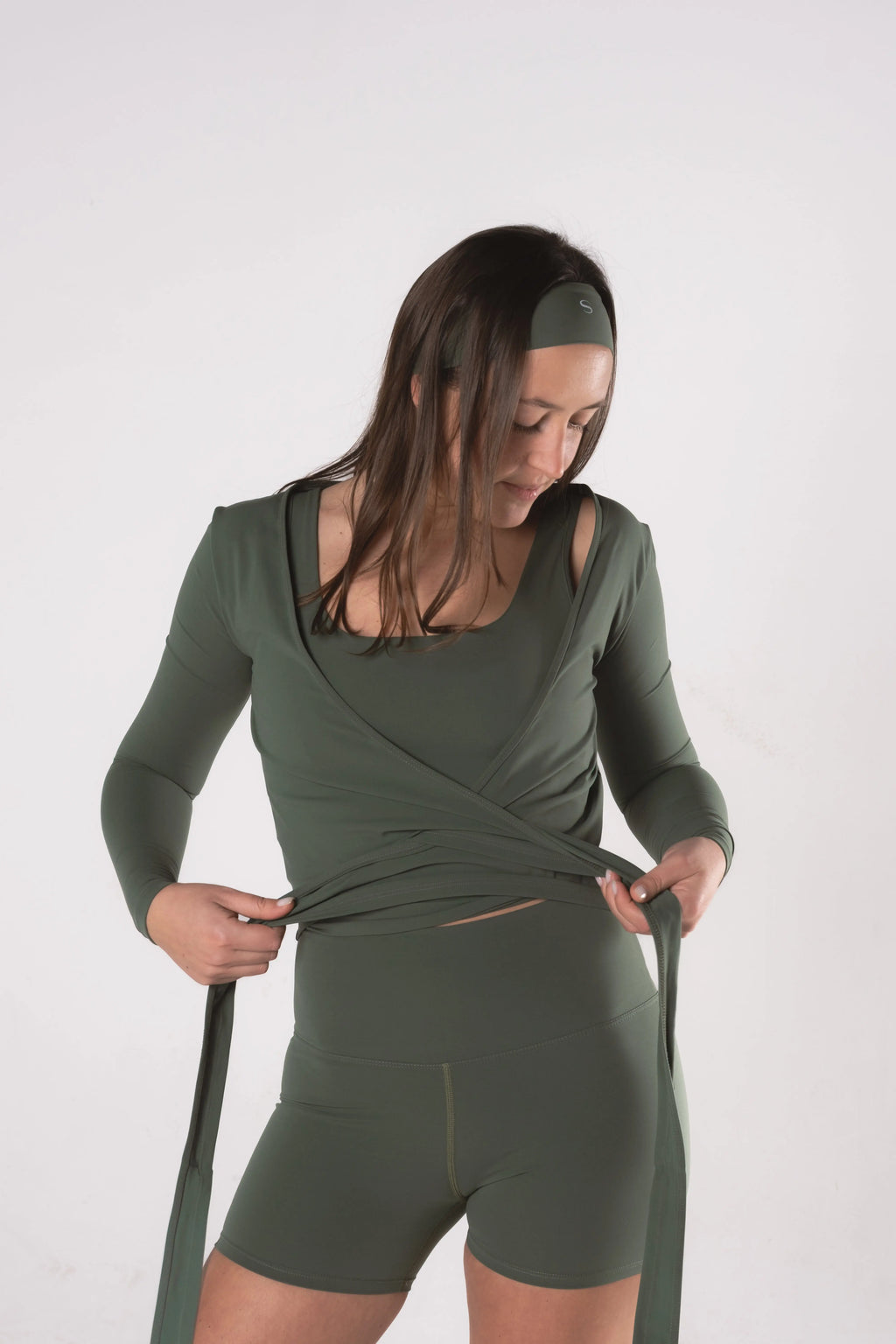 Woman wearing LESS Activewear Wrap Top, feminine coverage top for pilates