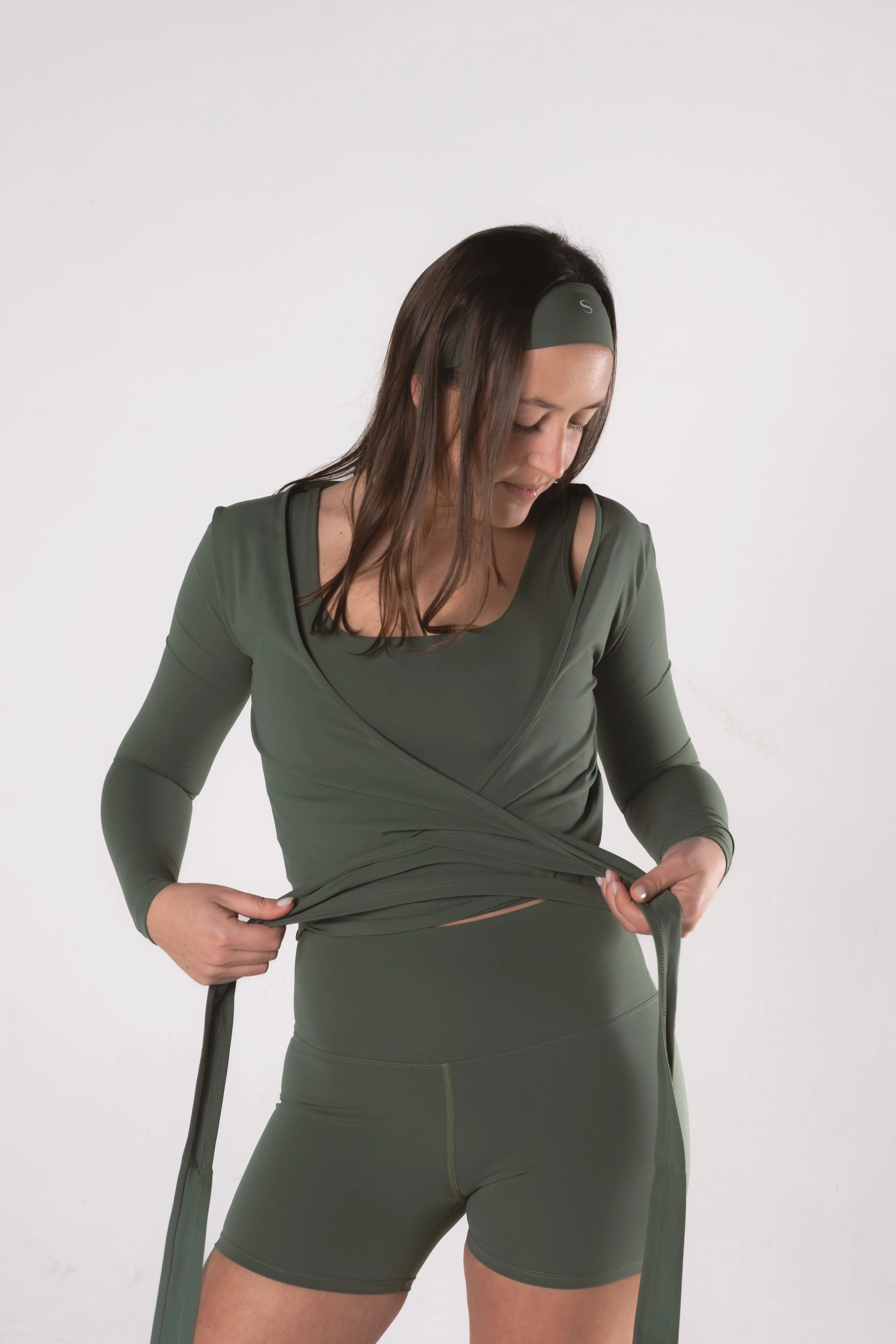 Woman wearing LESS Activewear Wrap Top, feminine coverage top for pilates