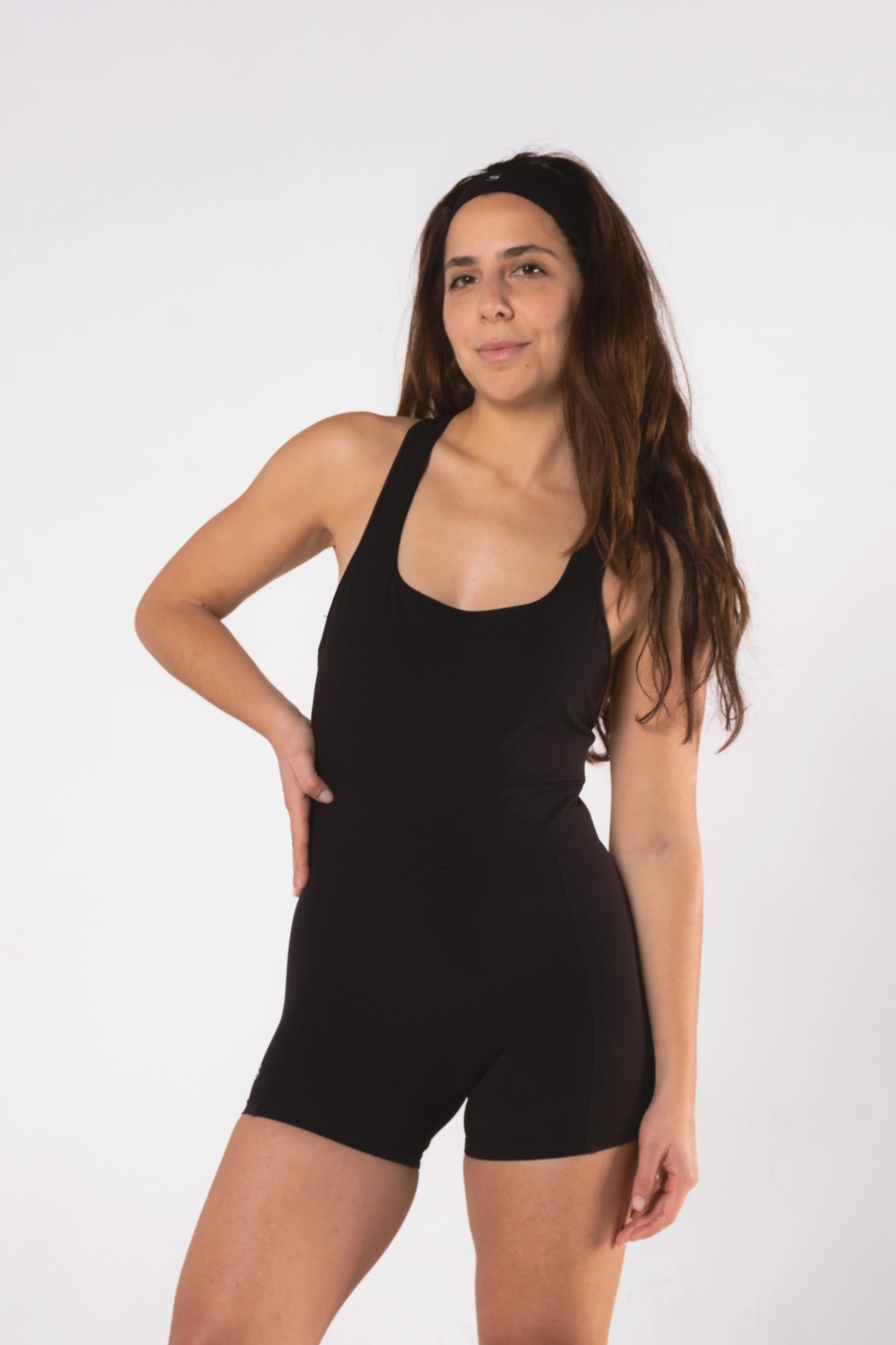 Woman wearing LESS Activewear Flex Short Jumpsuit, designed for hot yoga and hot pilates