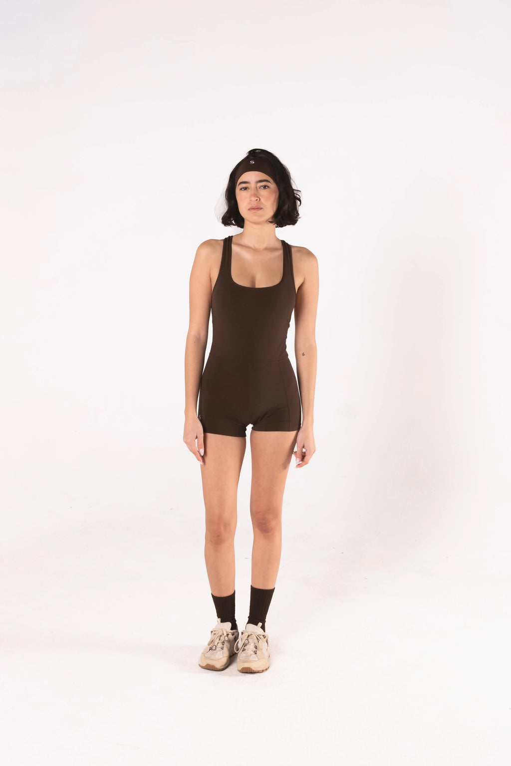 Woman wearing LESS Activewear Flex Short Jumpsuit, designed for hot yoga and hot pilates