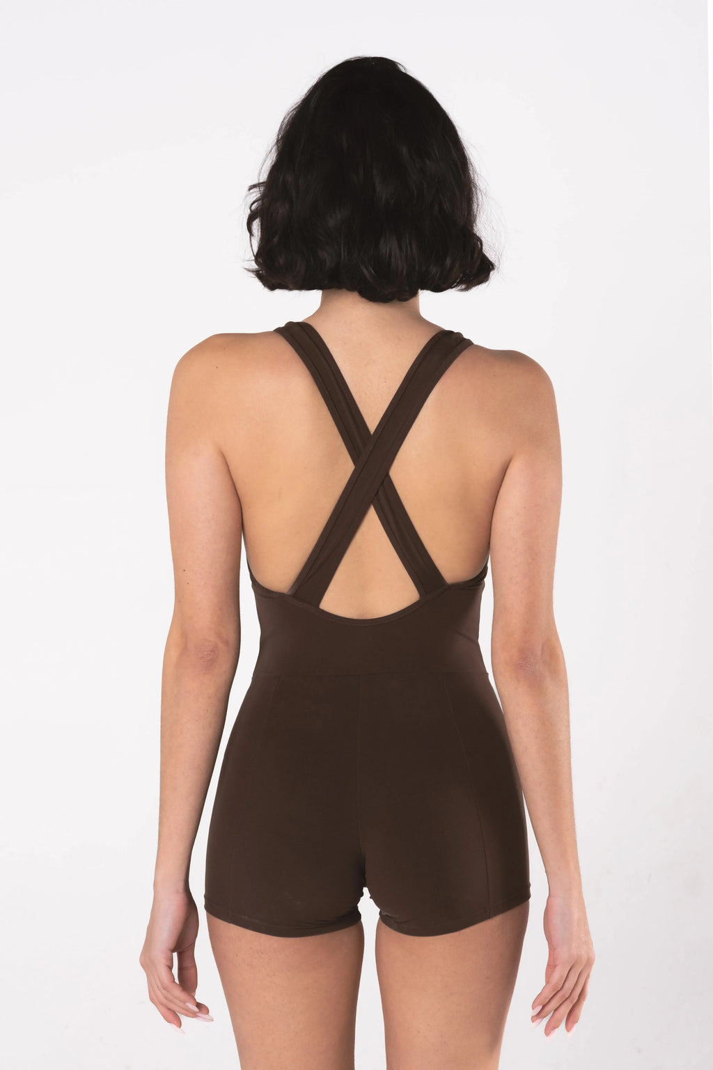 Woman wearing LESS Activewear Flex Short Jumpsuit, designed for hot yoga and hot pilates
