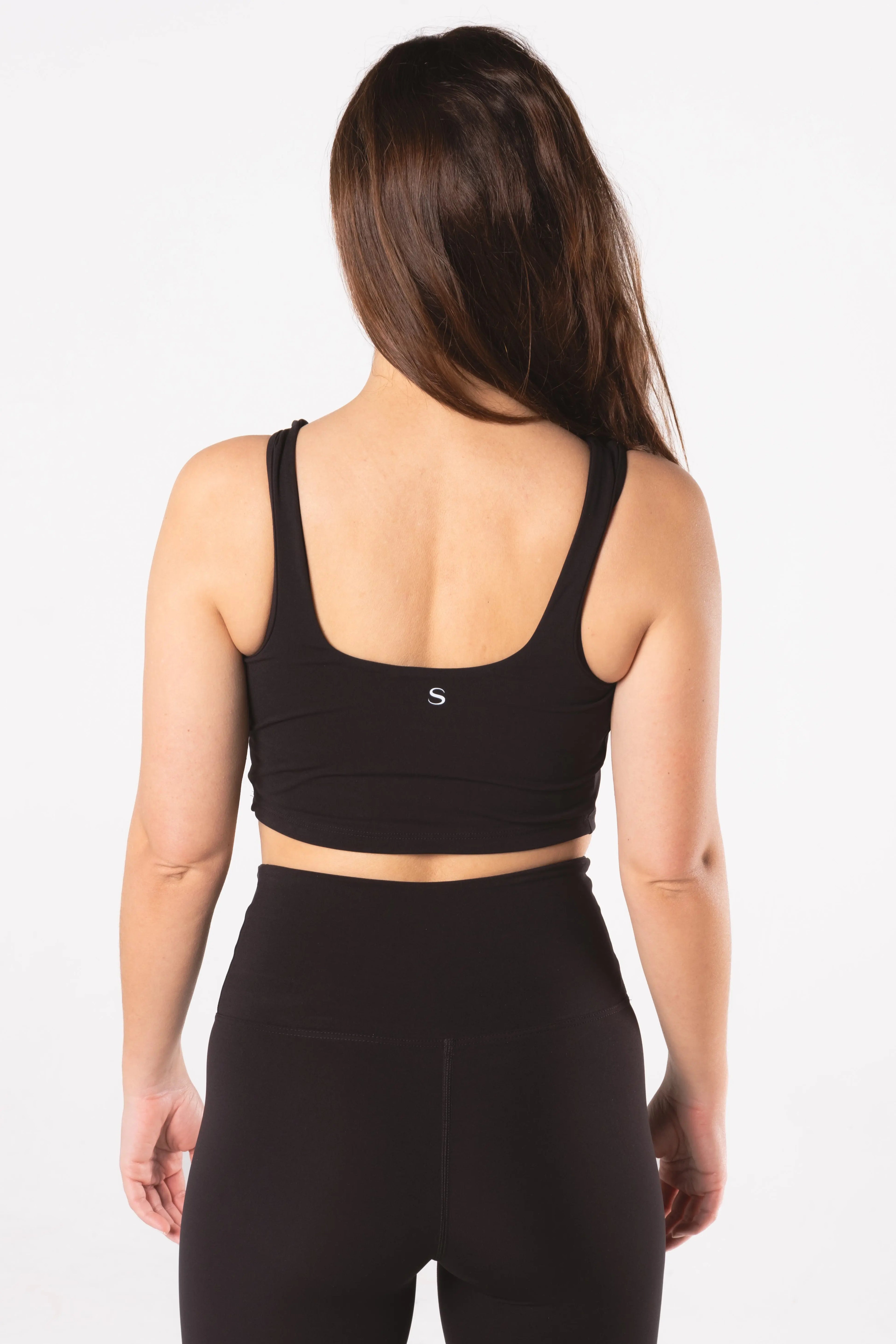 Woman wearing LESS Activewear Base 02 Crop Top, designed for medium busts