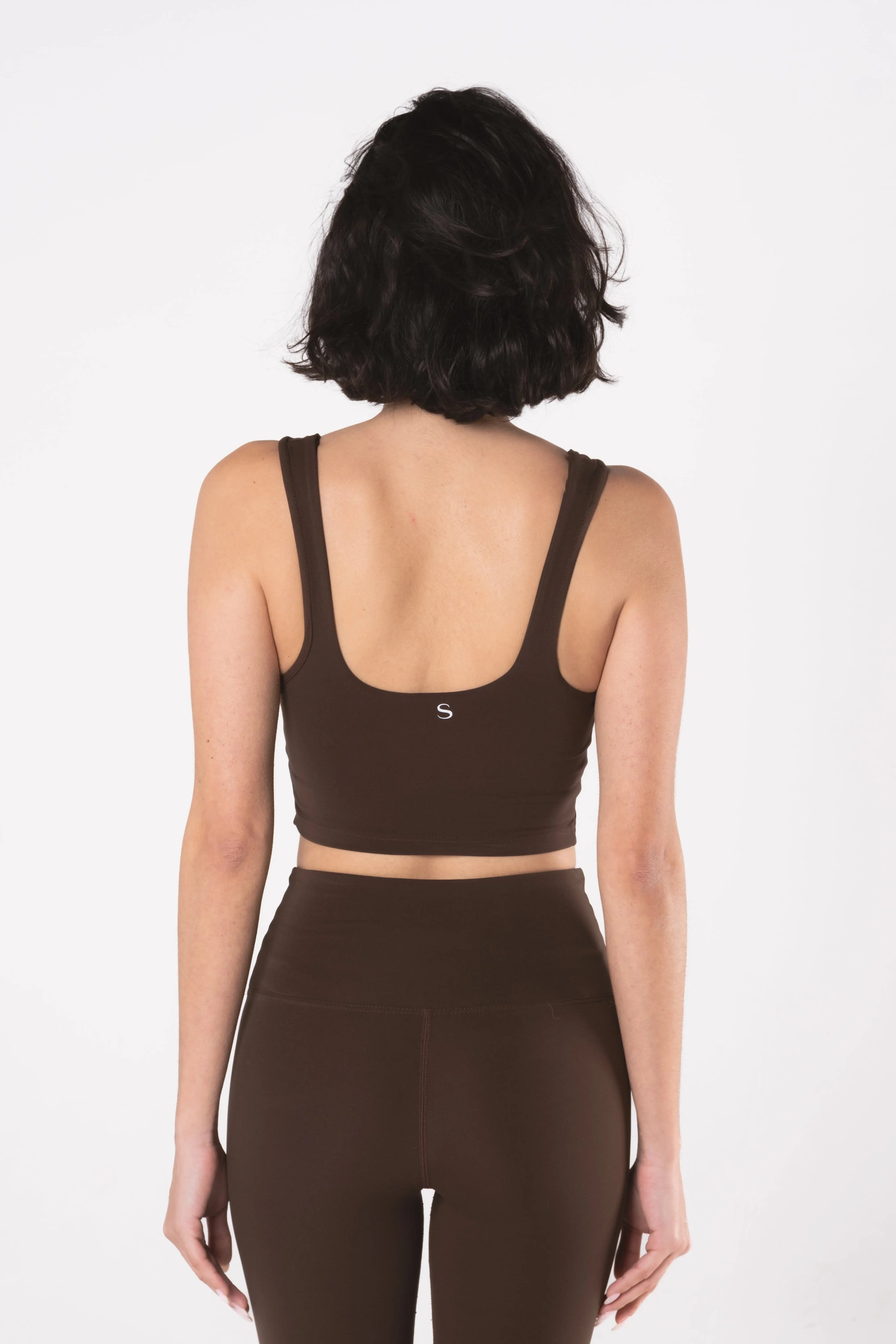 Woman wearing LESS Activewear Base 02 Crop Top, designed for medium busts